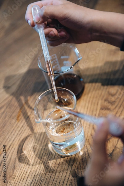 Fototapeta hands holding a pipettes with chemestry
