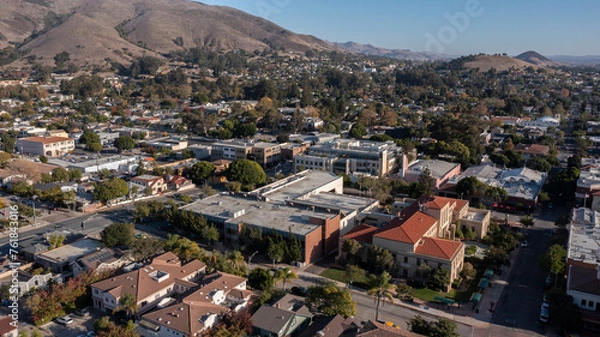 Fototapeta San Luis Obispo, California, USA - December 3, 2021: Aerial view of afternoon light shining on the historic buildings of the downtown core.