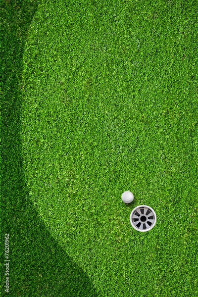 Fototapeta The ball at the hole on the golf course