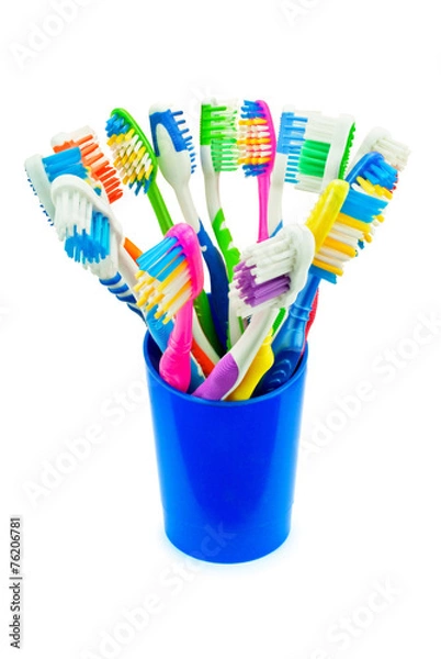 Obraz Разноцветные зубные щетки в синем стакане
