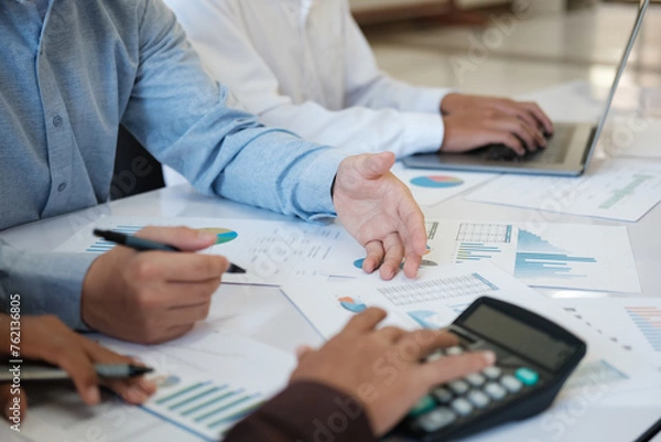 Fototapeta A team of business people is brainstorming to analyze investment project data.