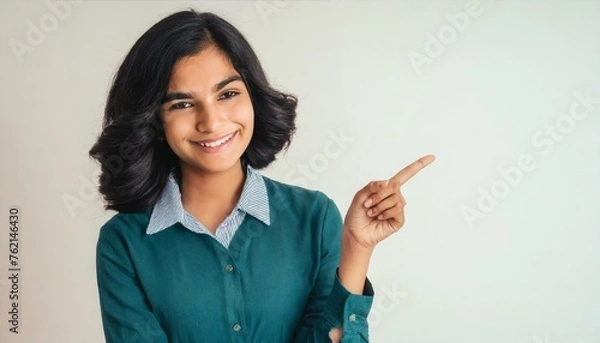 Fototapeta Firefly close-up of a beautiful smiling young Indian woman pointing point pose on copy space white ba (3)