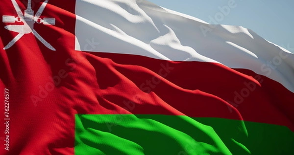 Fototapeta Close-up of the national flag of Oman flutters in the wind on a sunny day
