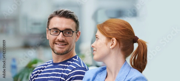 Fototapeta Man, woman and smile in startup office for conversation, team or advice for decision at company. Business people, happy and talk for negotiation, planning or listen to ideas at creative media agency