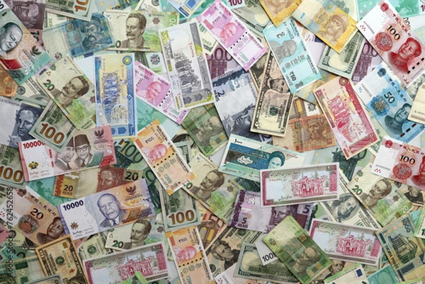 Obraz Many banknotes of different currency. Background of big amount of random money bills close up