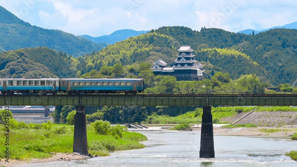 Obraz A limited express train on the Tokushima Line crossing the iron bridge over the Anabuki River in Ozu, Japan, Aug 2023