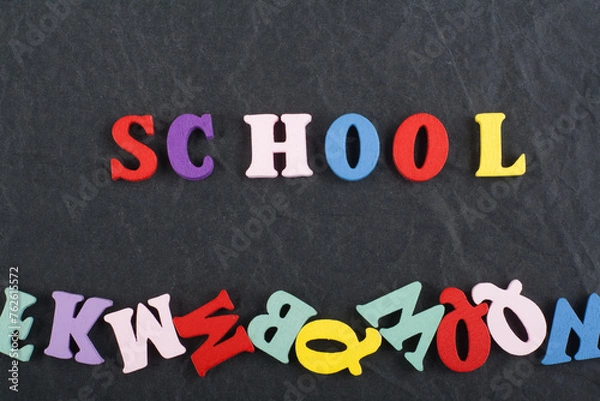 Fototapeta SCHOOL word on black board background composed from colorful abc alphabet block wooden letters, copy space for ad text. Learning english concept.