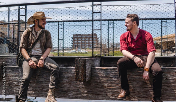 Obraz men sitting next to eachother on bench