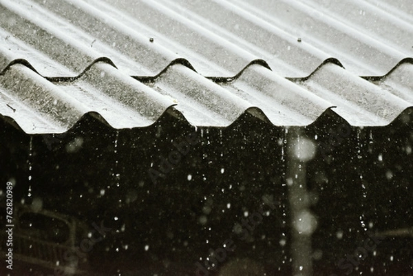 Fototapeta Rainy day in bad weather in summer, winter season. Rain flows down from old roof house. On rainy days, it helps reduce air pollution. PM2.5 concept.