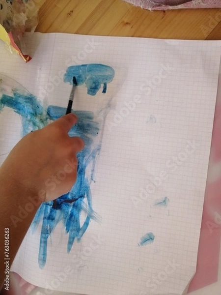 Obraz Child's hand and brush with paints. Blue