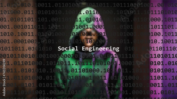 Obraz Social engineering cyber attack text in foreground screen, anonymous hacker hidden with hoodie in the blurred background. Vulnerability text in binary system code on editor program.