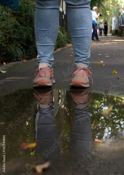 Obraz Schuhe einer Weiblichen Person spiegeln sich in einer Pfütze