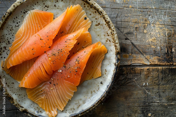 Fototapeta Top view of smoked salmon slices on a rustic plate, ideal for food blogs and culinary events.