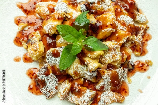 Obraz Kaiserschmarrn with iceing sugar and apple sauce on a white plate