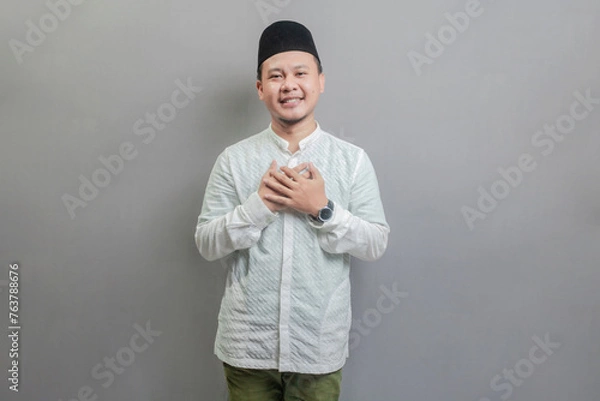 Fototapeta Asian Muslim man standing looking empty space happily to show grateful