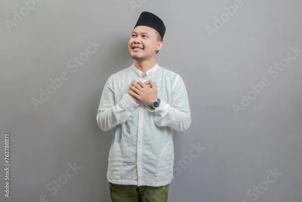 Fototapeta Asian Muslim man standing looking empty space happily to show grateful