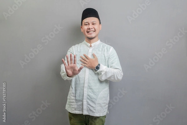 Fototapeta Asian muslim man doing stop sign with palm of the hand