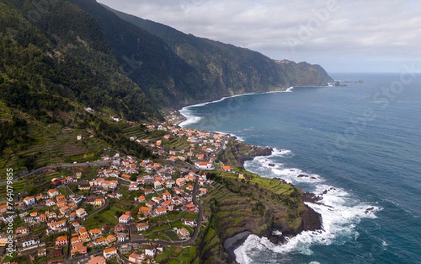 Fototapeta Aerial view of Seixal, a little village by the ocean with waves and surrounded with incredible mountains on the island of Madeira, Portugal.
