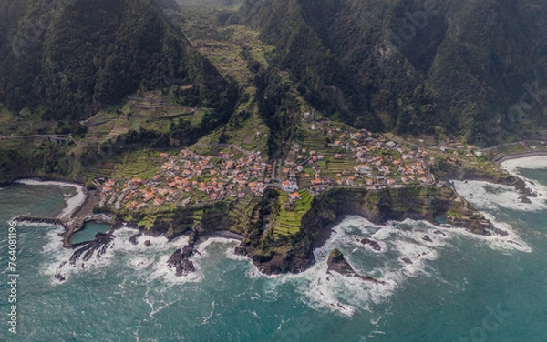 Fototapeta Aerial view of Seixal, a little village by the ocean with waves and surrounded with incredible mountains on the island of Madeira, Portugal.