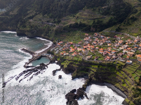 Fototapeta Aerial view of Seixal, a little village by the ocean with waves and surrounded with incredible mountains on the island of Madeira, Portugal.