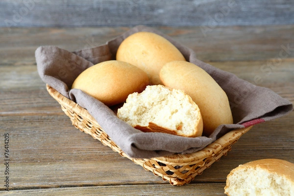 Fototapeta Buns in a wicker basket on the boards