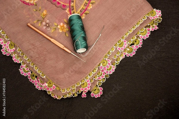 Fototapeta Hand-knitted scarf and headscarf samples, handmade embroidered and red head scarf, crochet and knitting thread close-up.