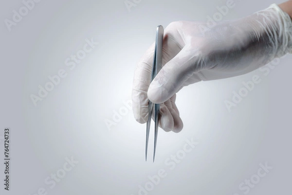 Obraz Close up Doctor's hand with Latex gloves taking the 
stainless tweezers to help the patience people on white gray background.