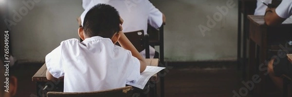 Fototapeta Stressed Student taking exam in classroom.Assessment examination of high school students dressed in uniform