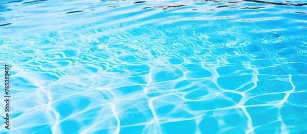 Fototapeta A close-up view of a serene pool filled with transparent water reflecting the clear blue sky above