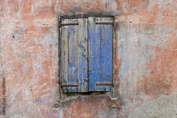 Fototapeta un vieux volet avec de la peinture bleue ecaillée avec un mur ancien ocre provençal