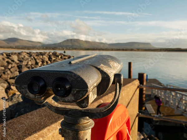Fototapeta Viewing binoculars with stunning nature ocean and mountain scenery in the background. Cost of Mullaghmore, county Sligo, Ireland. Travel and tourism. Sightseeing Irish fine landscape.