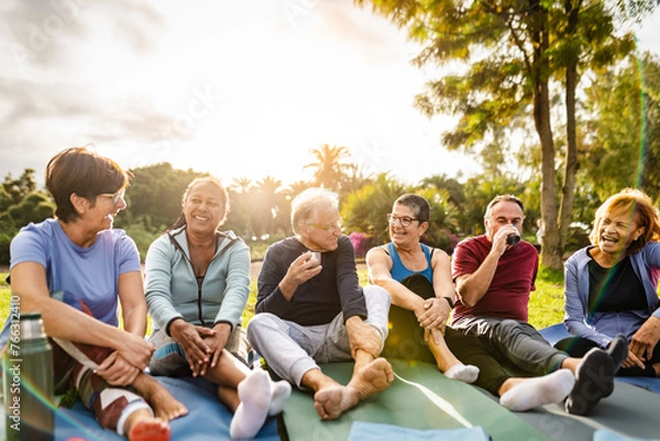 Obraz Happy multiracial senior friends drinking a tea after workout activities in a park