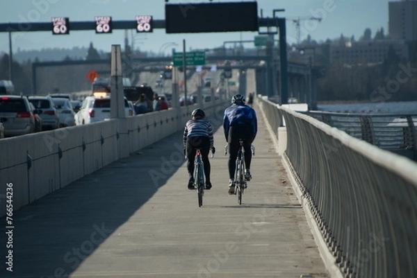 Obraz A couple of bicyclists ride from Eastside to Seattle on Evergreen Floating Bridge trail