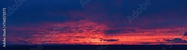 Fototapeta Ideal for sky replacement projects: panoramic aerial shot of a  red and orange illuminated clouds of dark blue evening sky just after sunset.