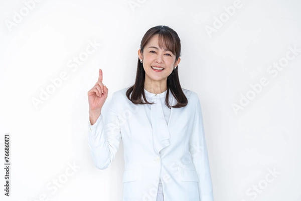 Obraz 白背景で指差しをするミドル女性