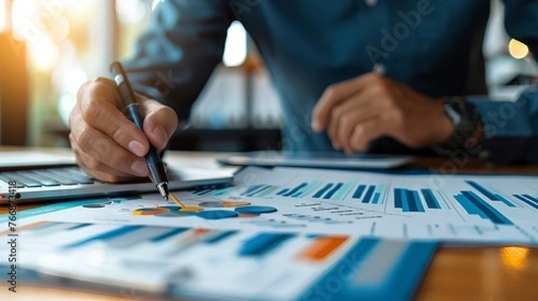 Fototapeta Businessman analyzing financial growth and investment data with strategy plan on blue background