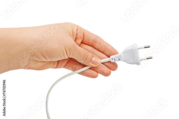 Fototapeta Hand holding electric plug. Isolated on white