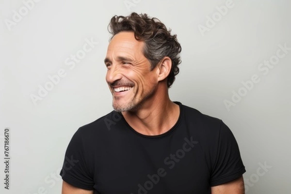 Obraz Portrait of a handsome middle-aged man laughing over gray background