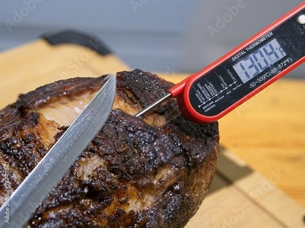 Obraz Smoked and grilled beef eye of round pulled from the heat to rest, knife ready to cut, thermometer is over 130 F