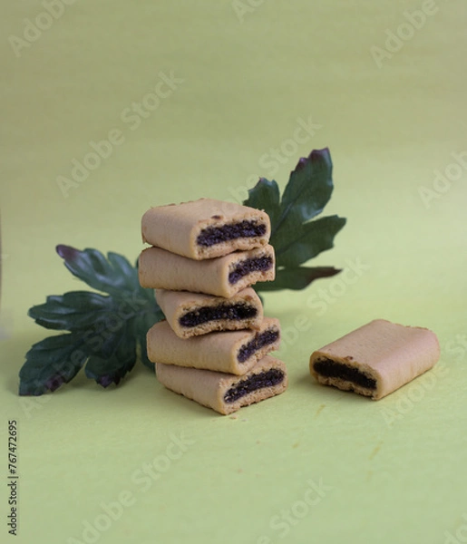 Obraz Fig bites on a yellow background with green leave on the back.