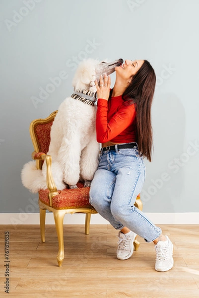 Obraz Joyful Moment as Fluffy White Dog Licks Smiling Womans Face in Cozy Room