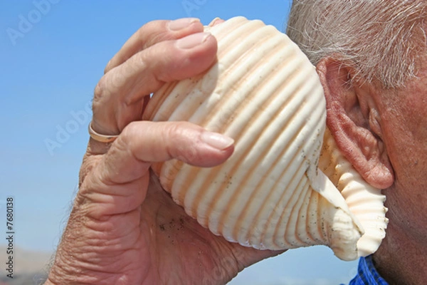 Obraz Senior listening to a shell