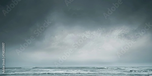 Fototapeta A vast body of water under a dramatic grey sky filled with clouds. Dramatic grey sky.
