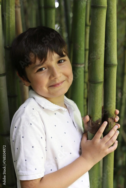 Obraz niño sonriente posando entre bambús