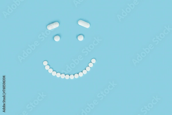 Obraz smiling smiley face made of pills on a blue background