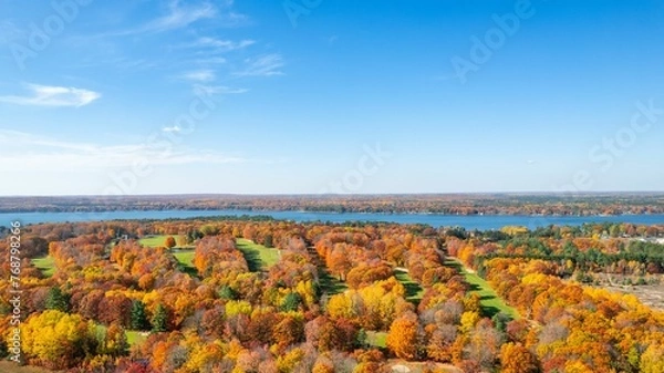 Fototapeta Aerial view of an autumnal scene of trees on the banks of a Cut River, in Michigan
