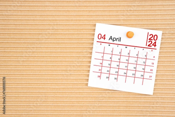 Fototapeta April 2024 calendar page with push pin on brown cardboard.