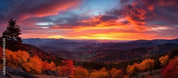 Fototapeta The sun setting over a serene autumn landscape, showcasing the mountains, trees, and colorful foliage