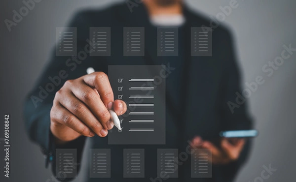 Fototapeta Document management system, DMS. Assessment form, questionnaire, checklist and clipboard task management. Businessman working with smartphone productivity checklist and filling survey form online.