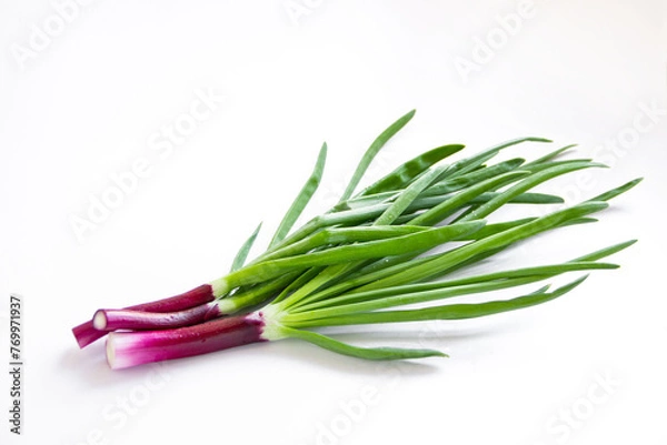Obraz Red onions on a white background. Fresh green onion feathers.